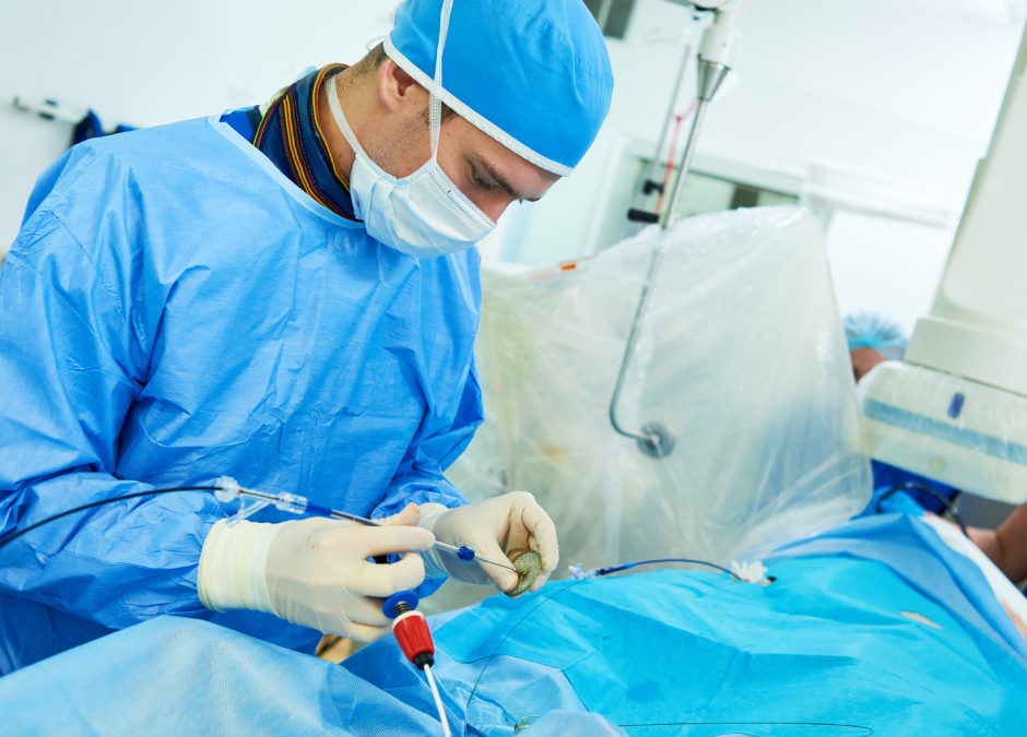 An interventional cardiologist is getting ready to insert a catheter in the patient's body, in a Cath Lab.